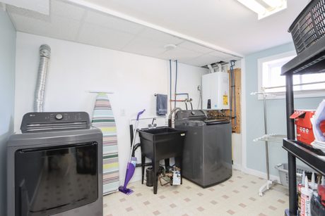 Separate laundry room with washer, dryer and laundry sink