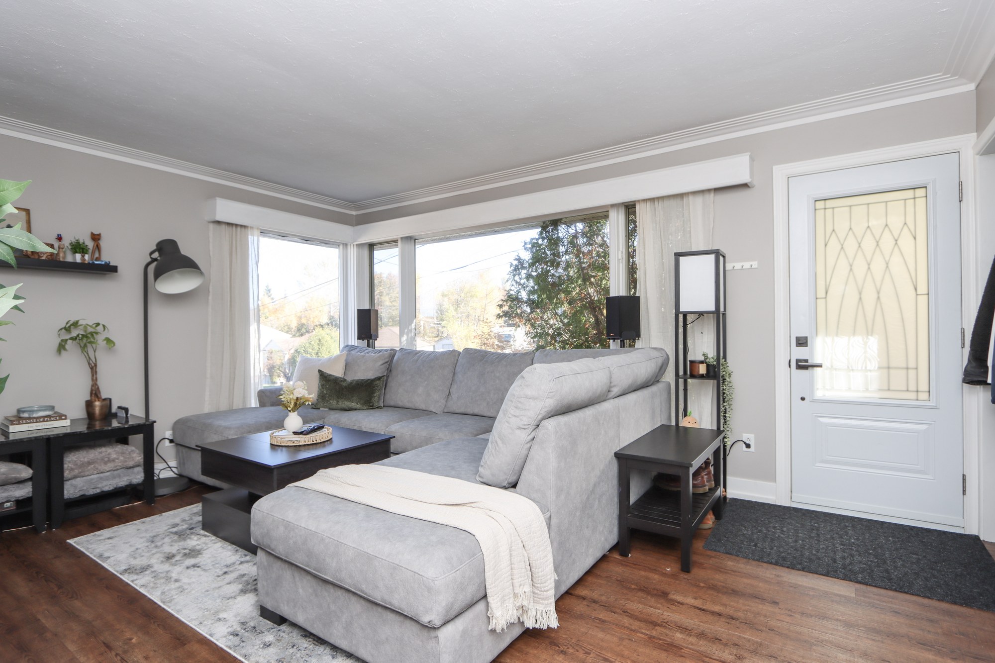 Living room with large corner windows and a grey sectional