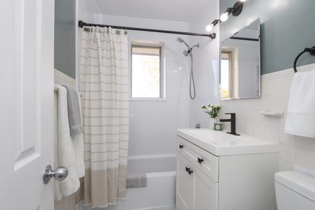 Main-floor bathroom with tub and white vanity