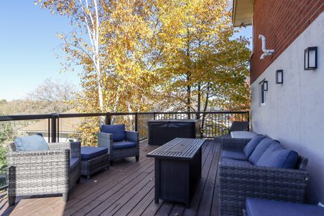 Back deck with outdoor seating and a treetop view